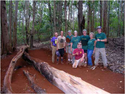 Proud volunteers pose in front of their newly completed section of hiking/mountain biking trail near Makawao, Maui.